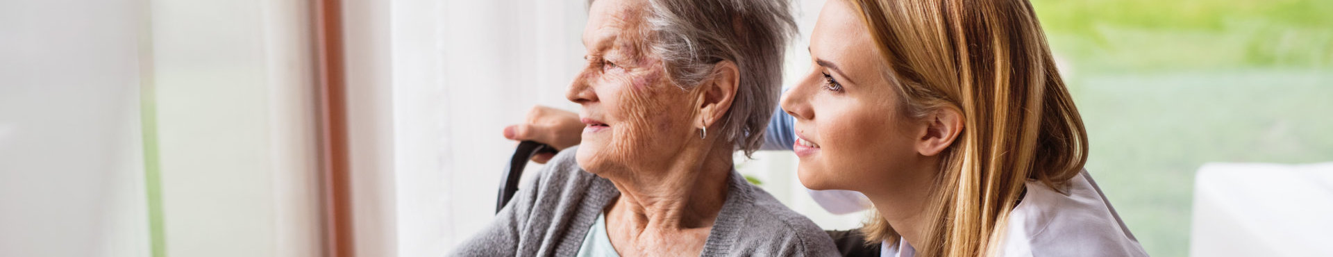 caregiver looking at the window with her senior patient